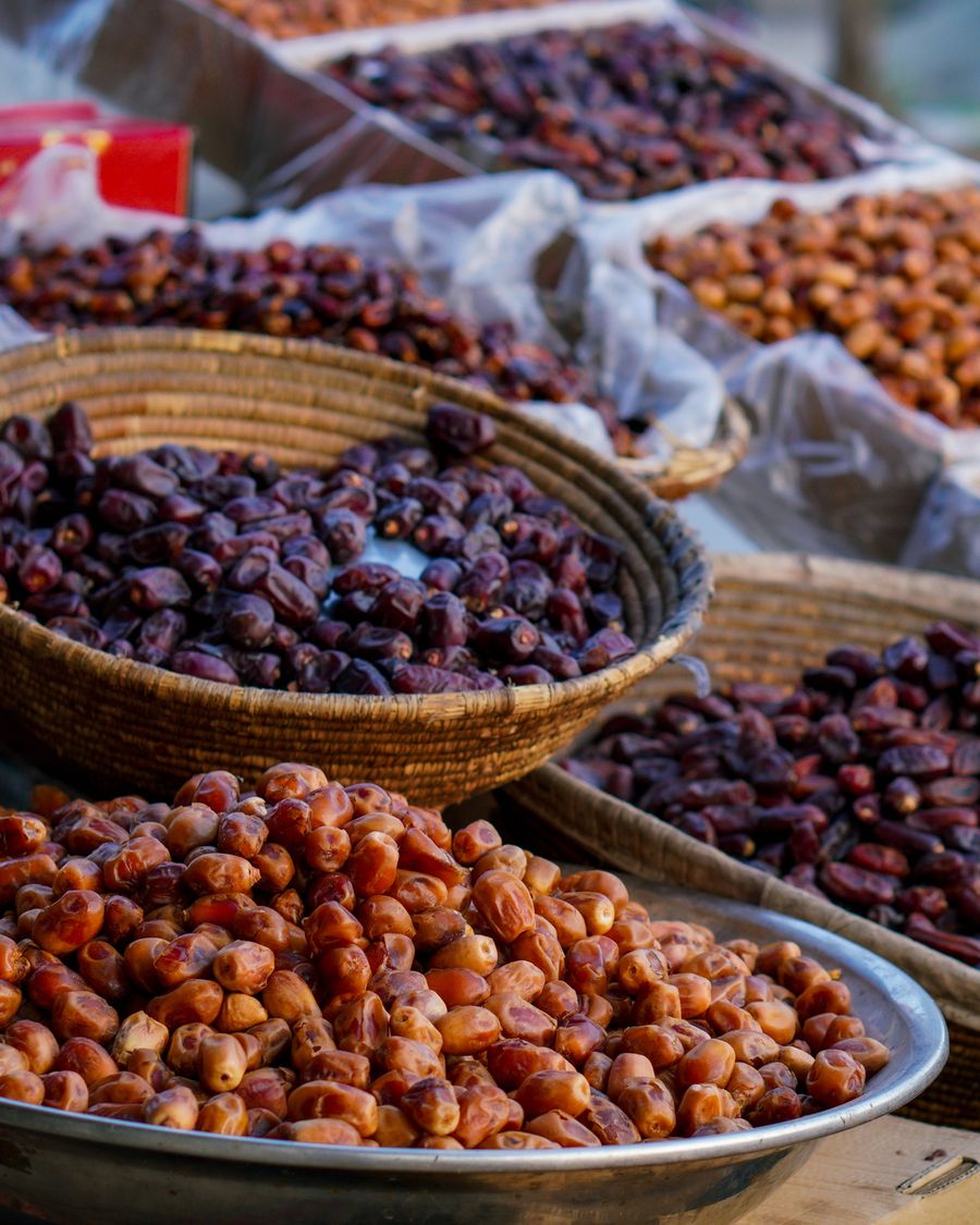 Baskets of fresh and dried dates at a market.